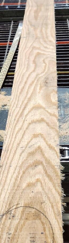 A piece of wood being cut on a machine.